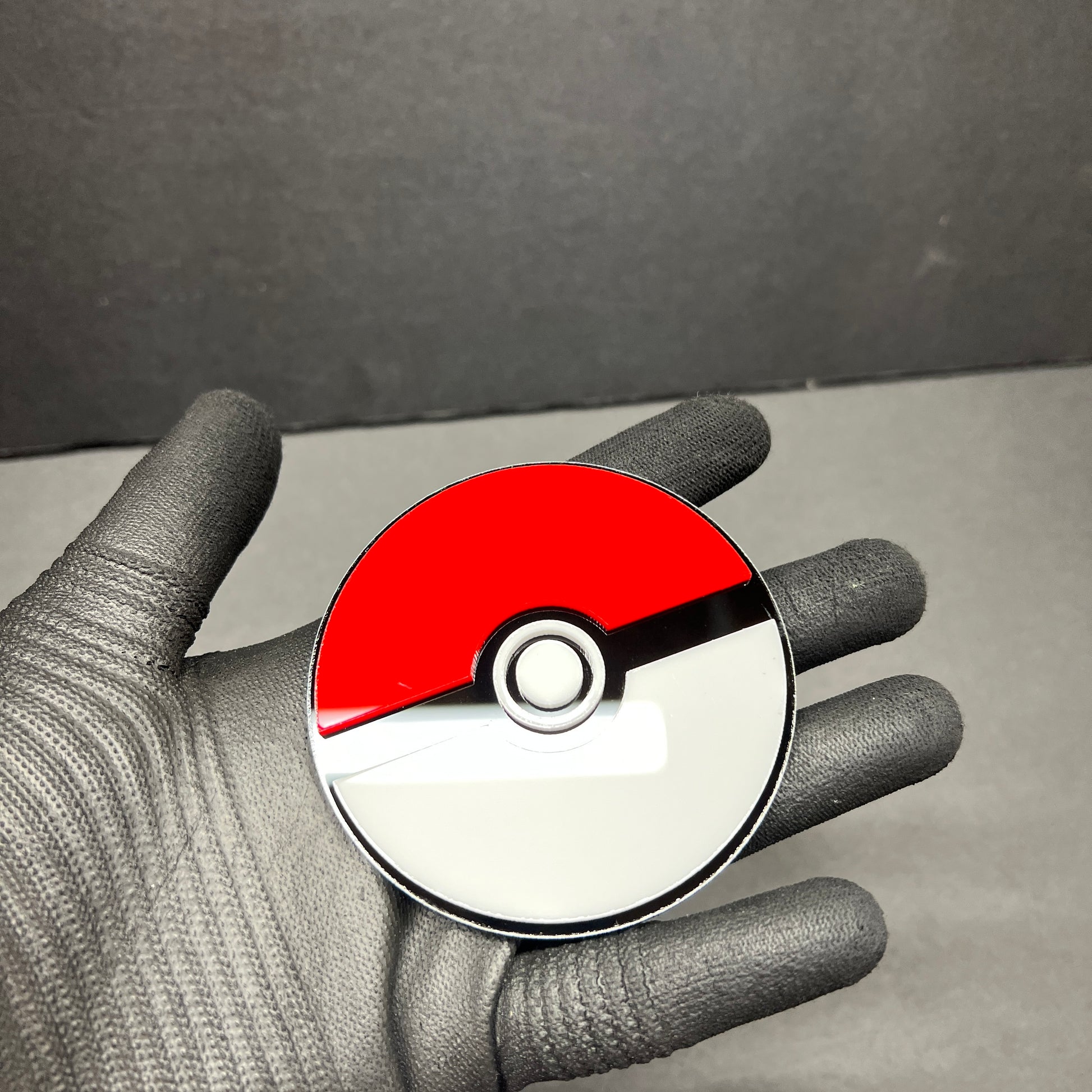 Glossy red white gaming inspired auto badge held in hand