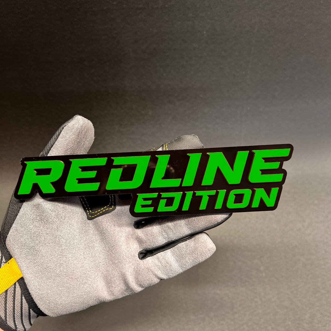 Gloss black Redline Edition badge with bright red acrylic lettering