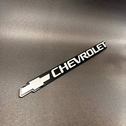 1999-2006 Chevrolet silver tailgate emblem featuring the classic Bowtie logo.