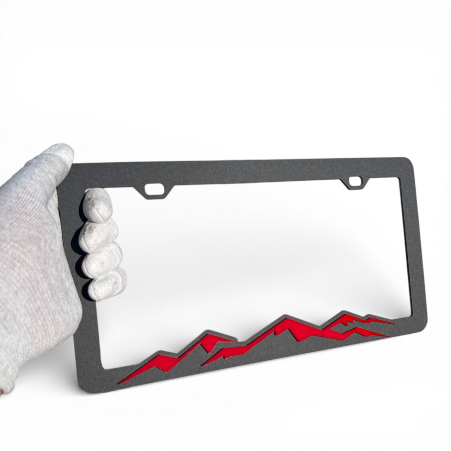 Black license plate holder with red mountain graphic for adventure vehicles