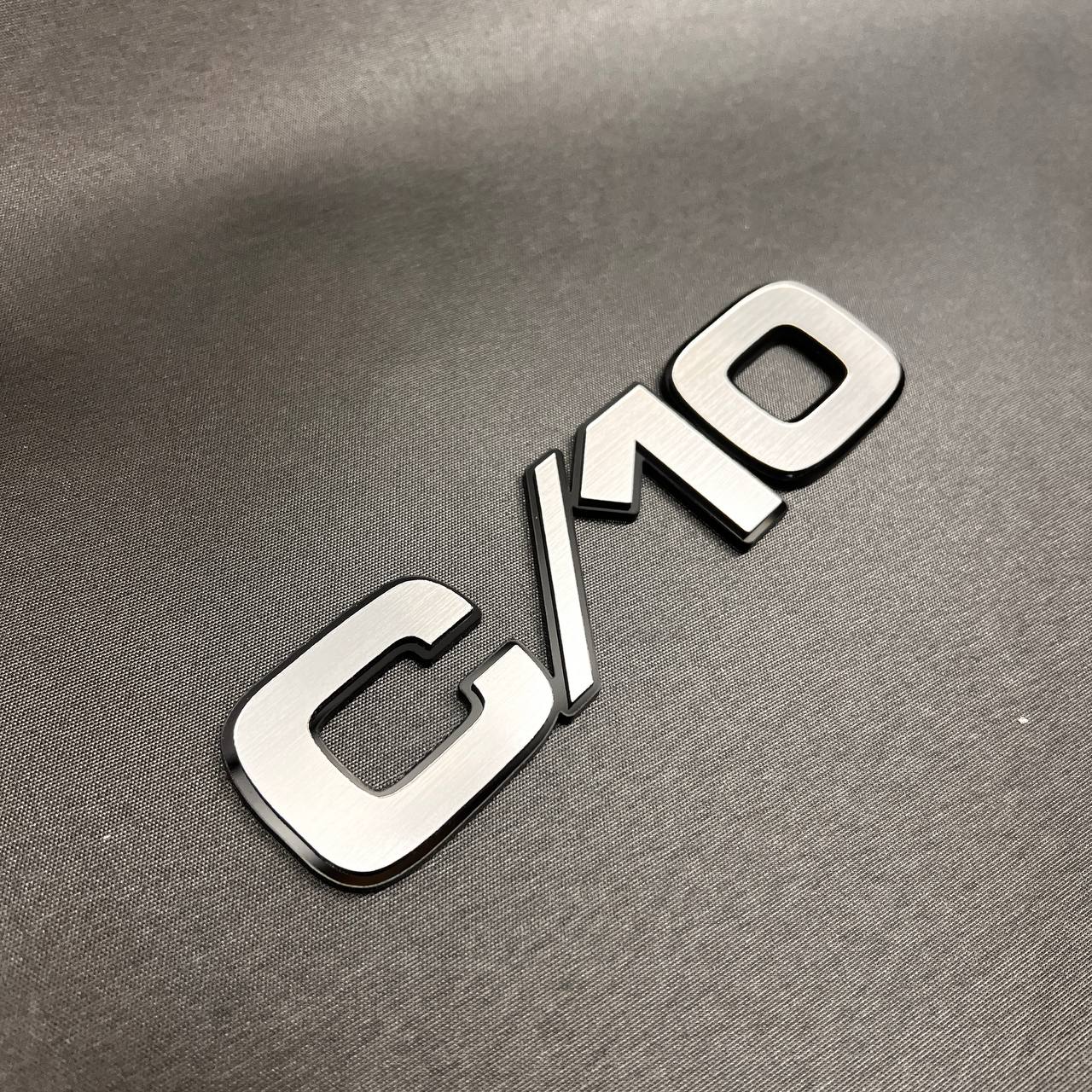 Chevy C/10 truck fender badge with brushed billet look and black outline