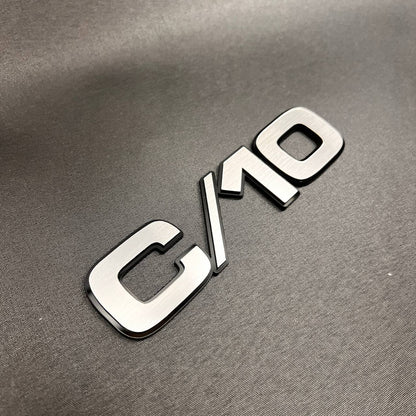 Chevy C/10 truck fender badge with brushed billet look and black outline