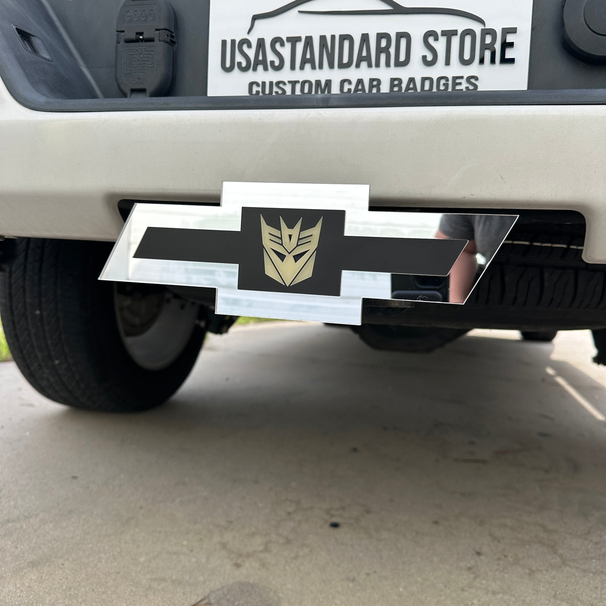 Chevy emblem silver glow in the dark Decepticon hitch cover mounted on a truck receiver