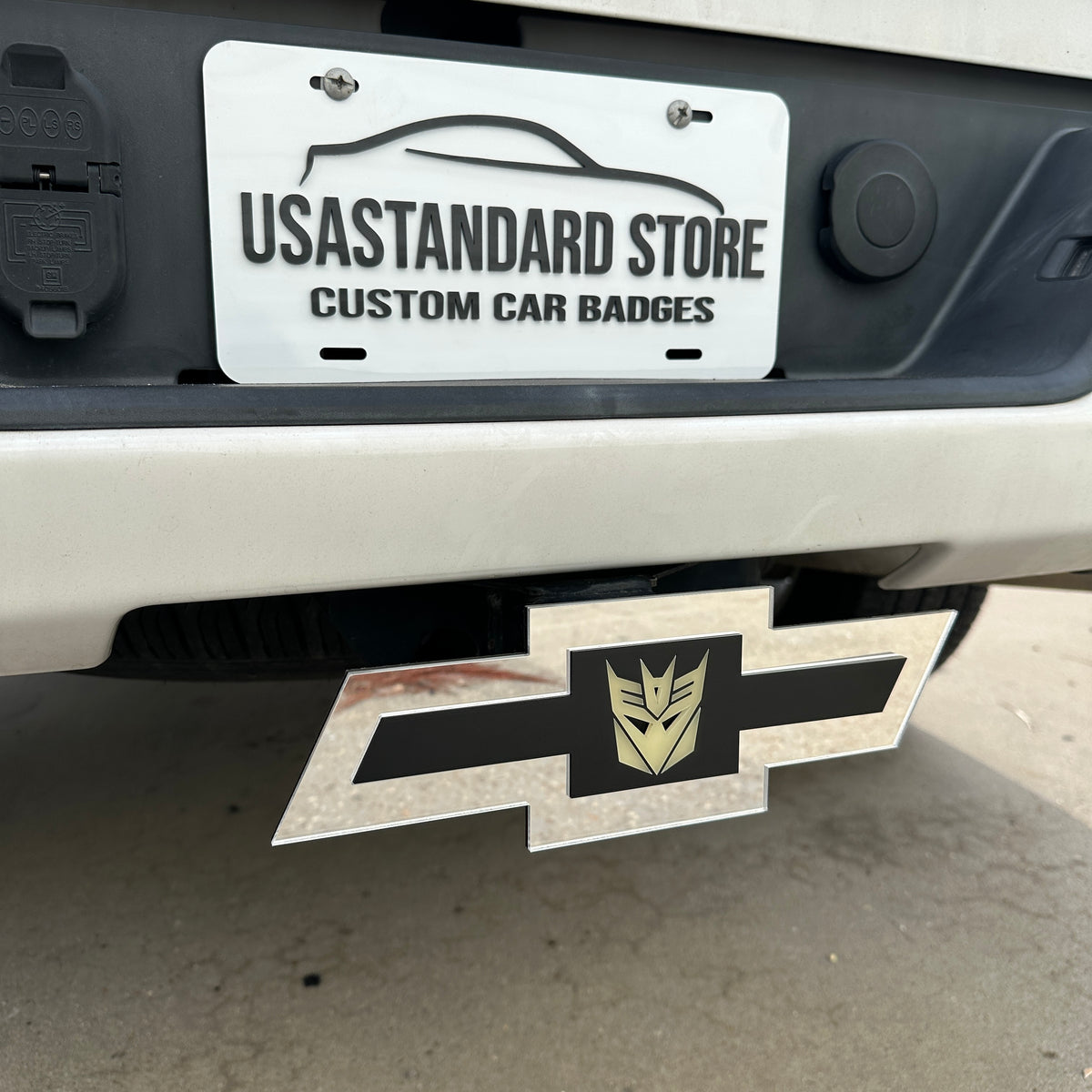 Silver Chevy hitch cover featuring a centered Decepticon emblem