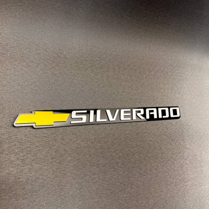 Custom Chevrolet Silverado tailgate badge featuring gold bowtie logo and white lettering.