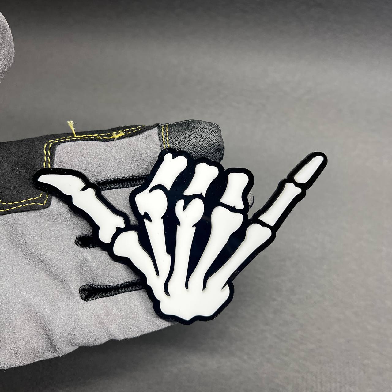 Skeleton shaka hand car badge fender emblem with black base and white bone design