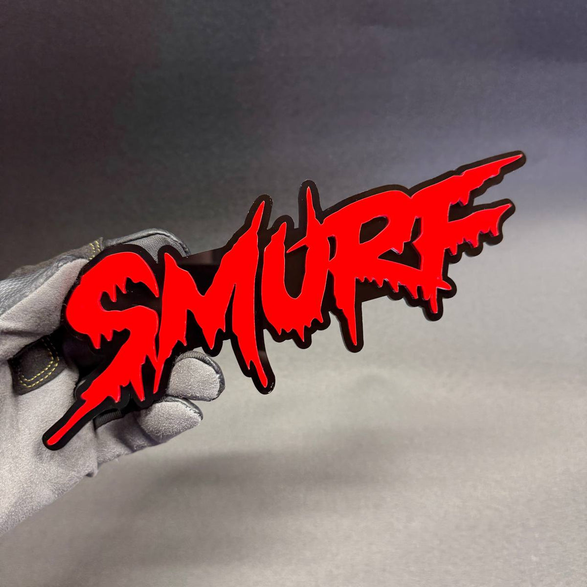 SMURF graffiti drip lettering car badge featuring bright red text with glossy black backing, custom fender emblem for Ford, Dodge and RAM vehicles.