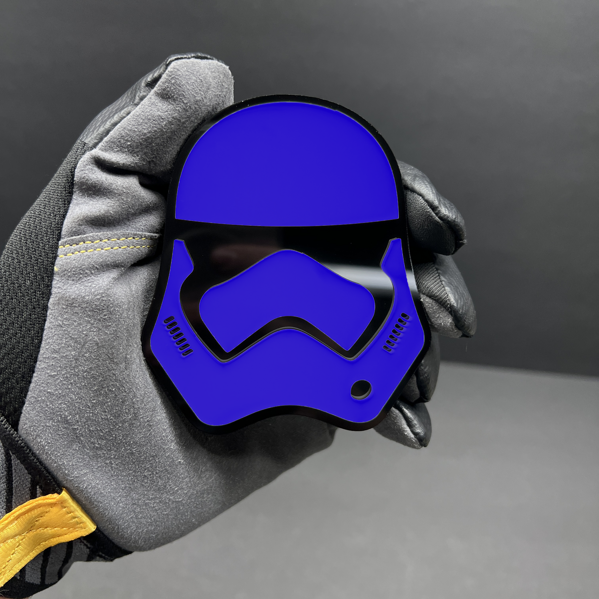 Red and black sci fi helmet car badge in hand