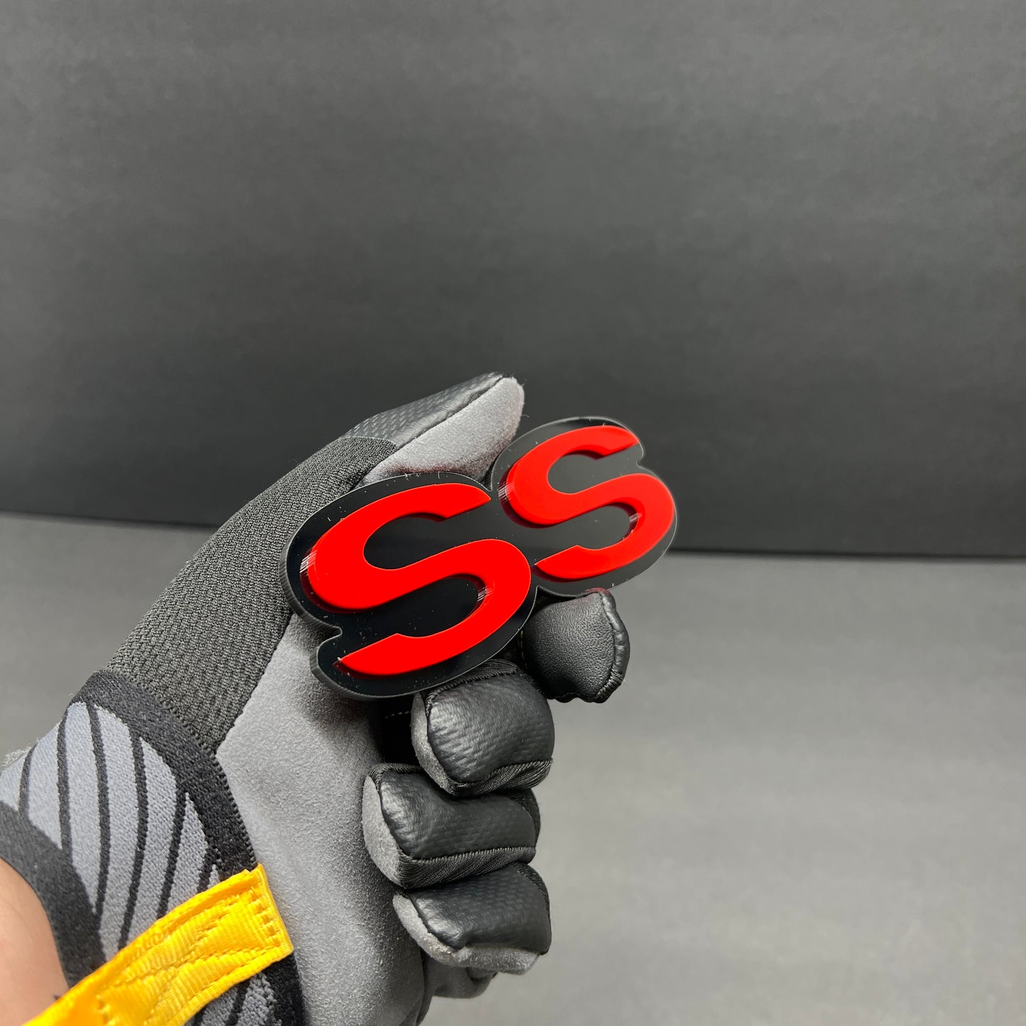 Custom SS car emblem with bold red lettering and black outline.
