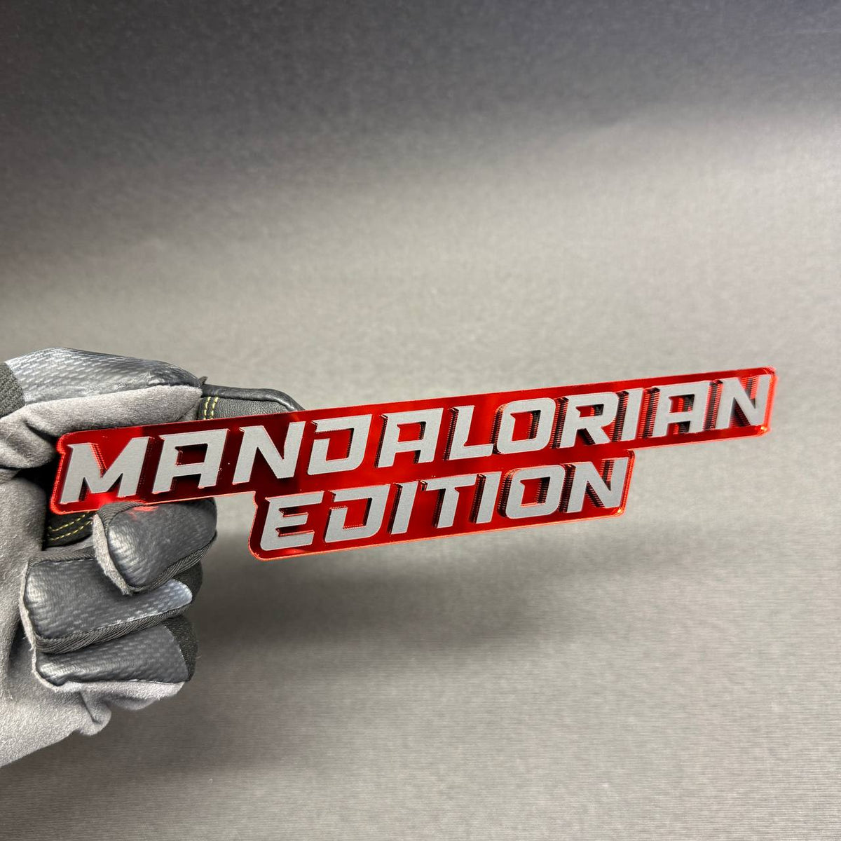 Mandalorian Edition custom automotive emblem with two-line lettering and red reflective finish, decorative fender badge for Dodge Ram 1500 and 2500.