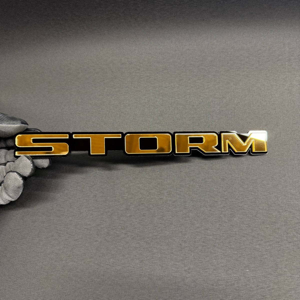 Gold STORM car badge with black background, custom automotive emblem for Ford F150, Chevy Silverado, GMC Sierra and RAM trucks.