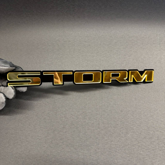 STORM gold and black custom car emblem, personalized text badge for Ford Mustang, F150, Dodge Charger, RAM, Chevy and GMC.