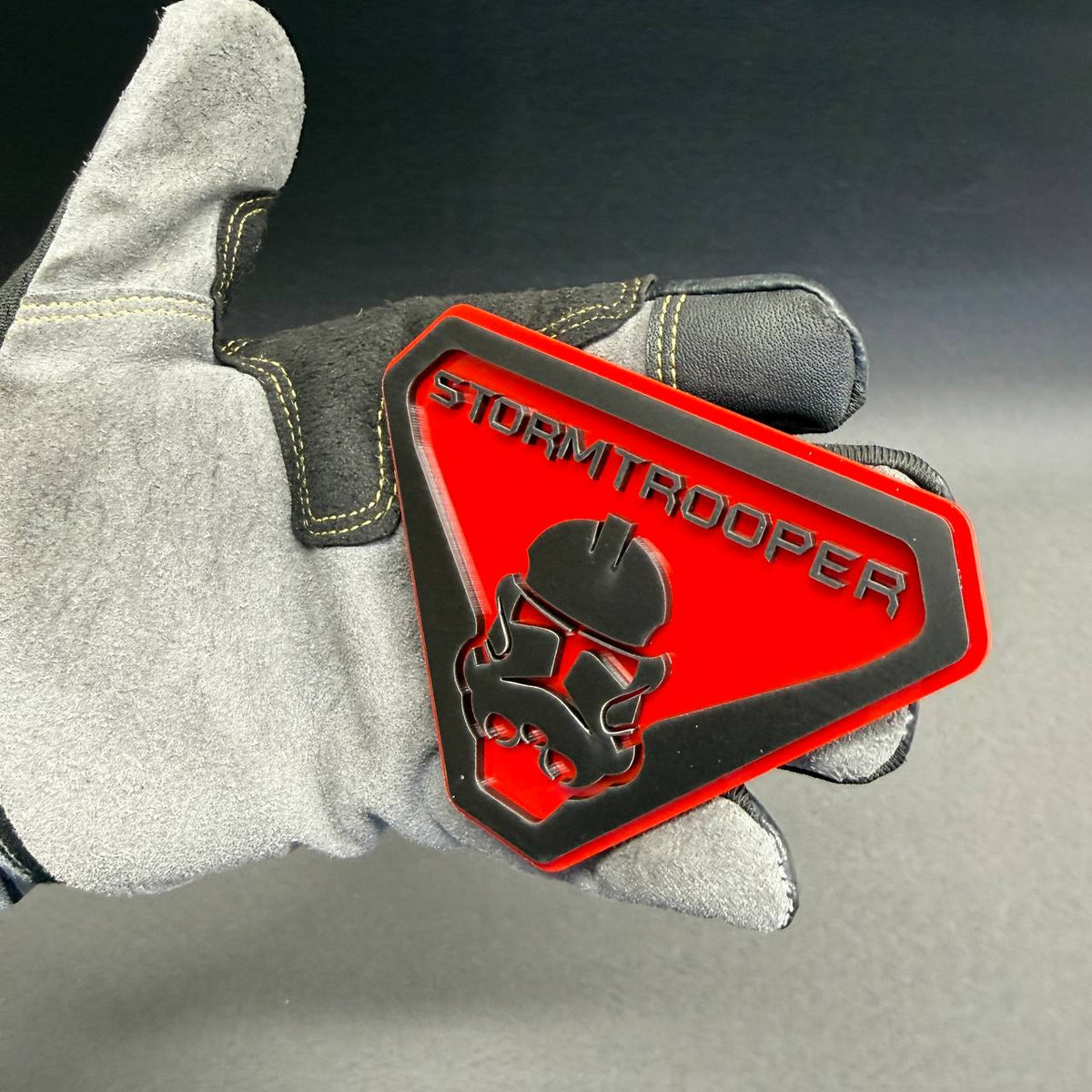 Stormtrooper helmet grille badge with bold black lettering and red finish, ideal for Ford F150, Bronco, Mustang and personalized truck accessories.