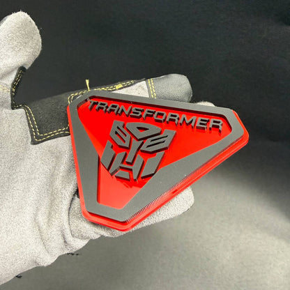 Custom Autobot Transformers car fender emblem in glossy red and silver, designed for Jeep Wrangler off-road styling.