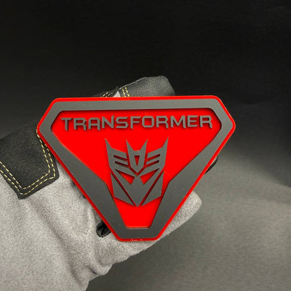Transformer Decepticon Badlands car badge featuring a red shield design with silver Decepticon robot logo and TRANSFORMER lettering