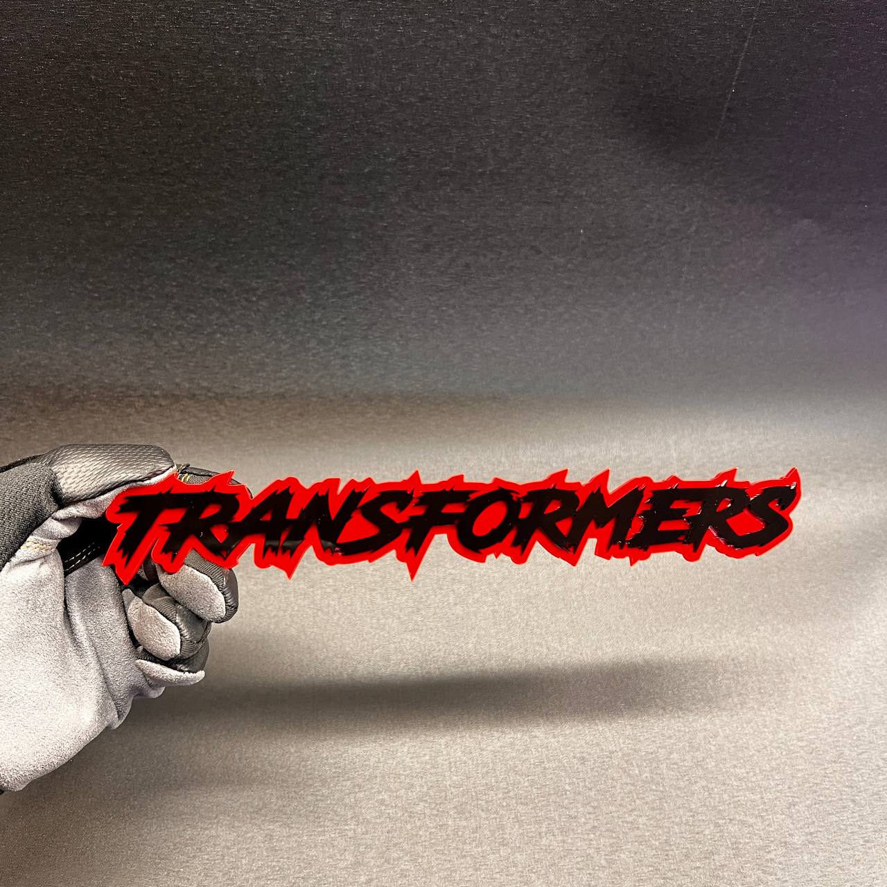 Red and black TRANSFORMER text car badge fender emblem with aggressive graffiti style design