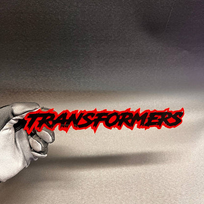 Red and black TRANSFORMER text car badge fender emblem with aggressive graffiti style design