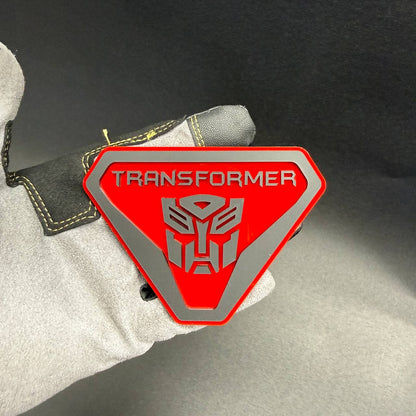 Transformer Autobot decorative fender emblem for Jeep Gladiator with red background, silver robot insignia and bold lettering.