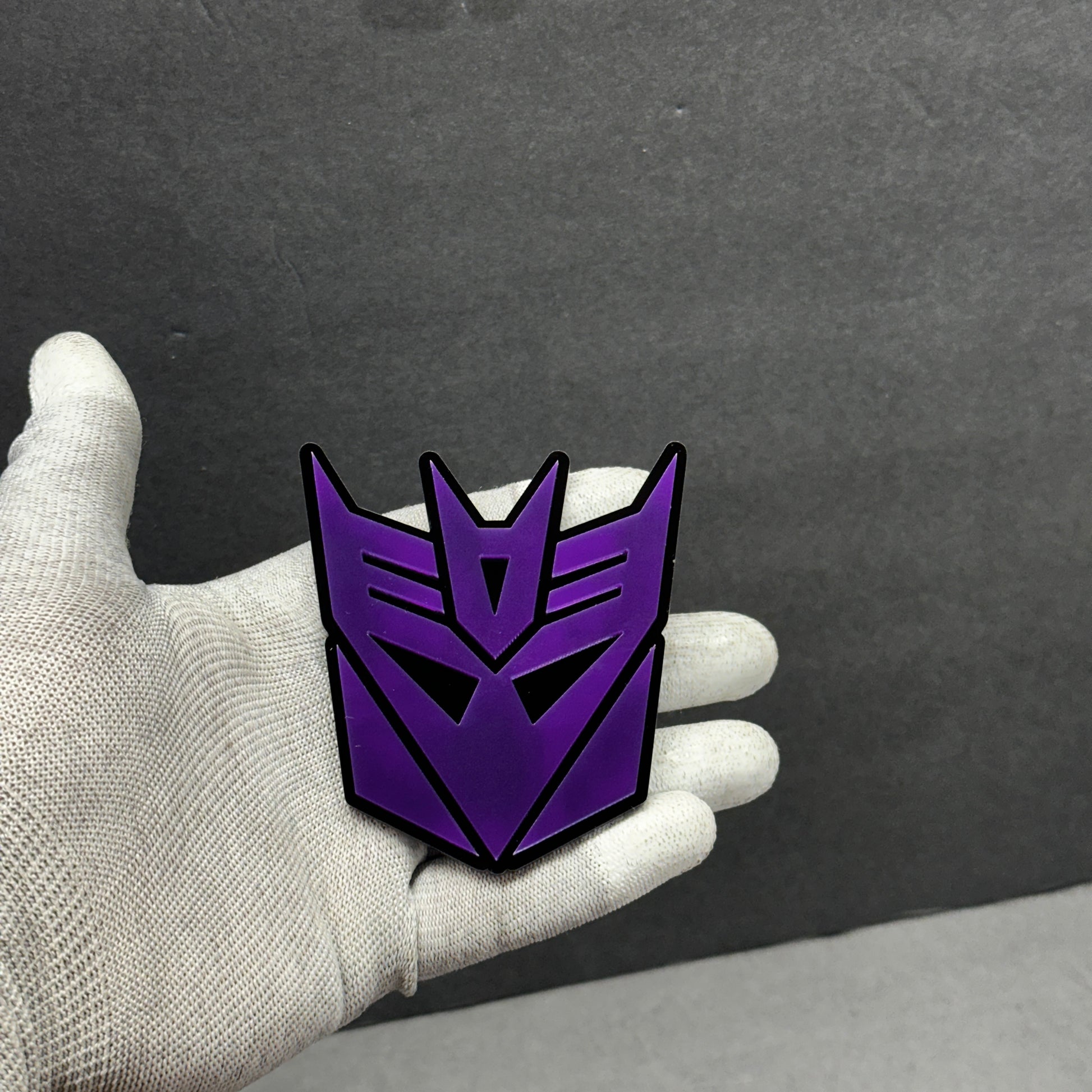 Close-up of purple Transformers Decepticon emblem – 3D acrylic car badge