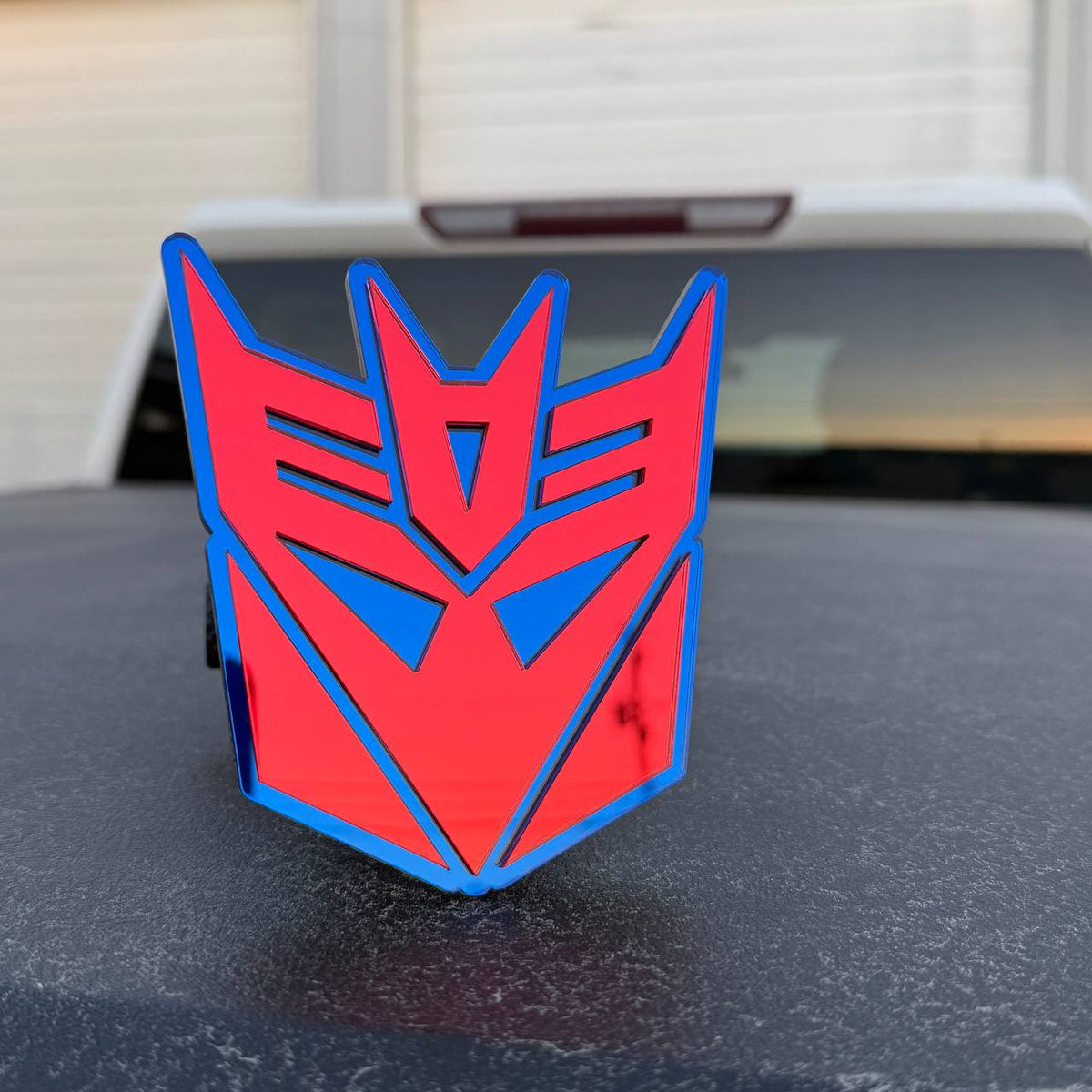 Transformers Decepticon logo hitch cover with reflective red and blue design for Ford F150 pickup truck.
