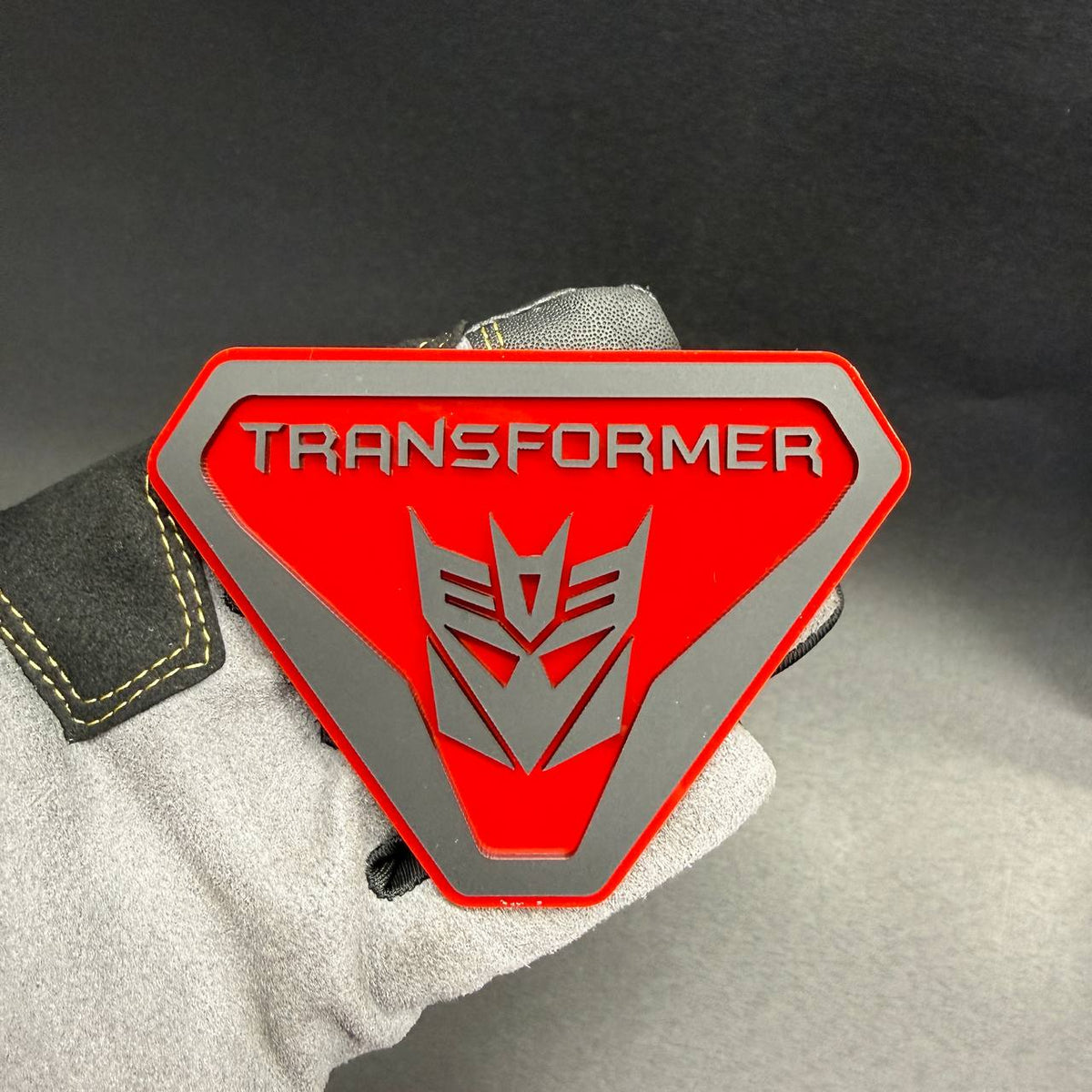 Transformer Decepticon Badlands shield emblem for Ford Bronco Badlands with bold TRANSFORMER lettering and silver robot insignia.