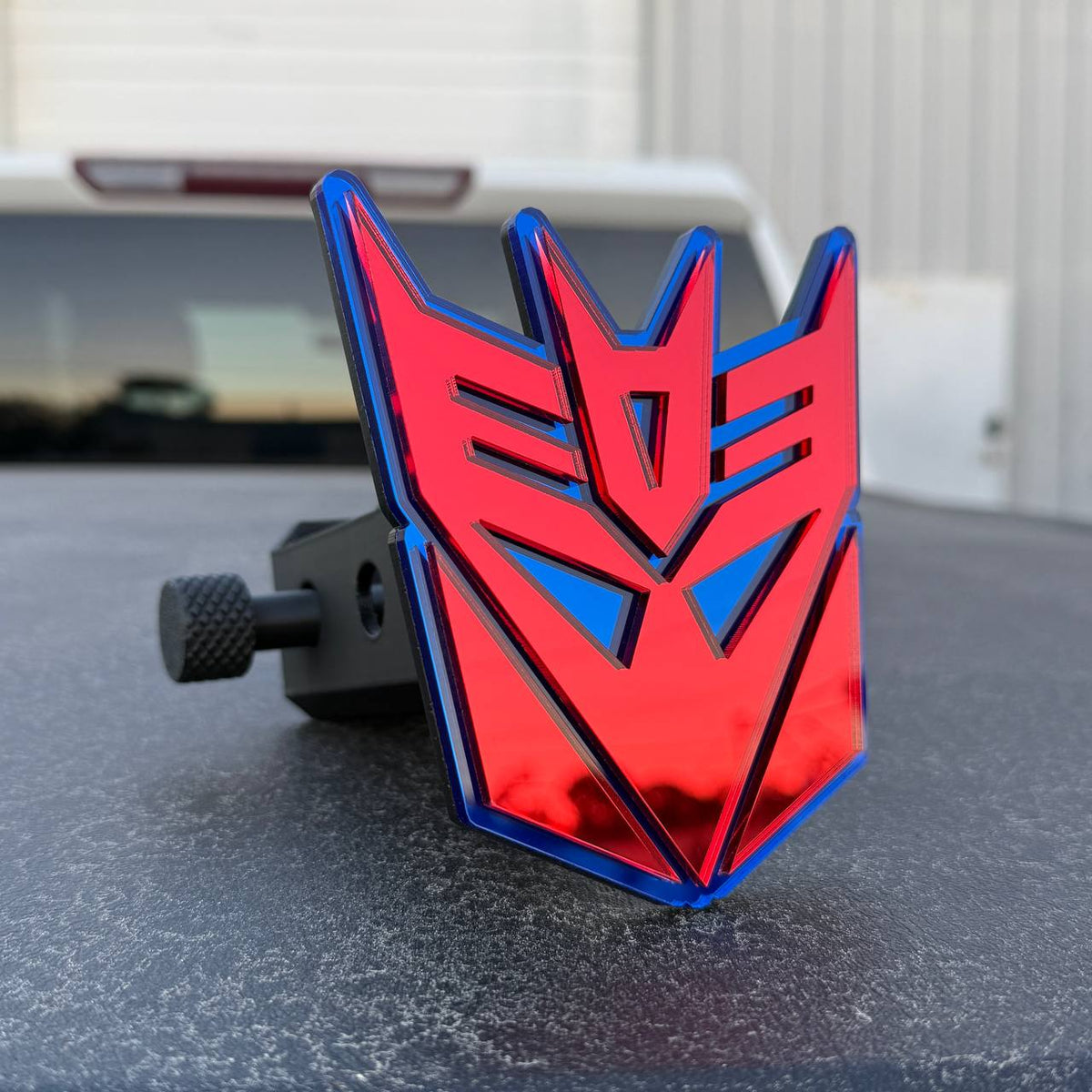 Transformers Decepticon symbol trailer hitch plug with layered acrylic design for GMC Sierra.