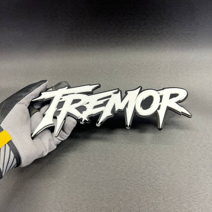 TREMOR performance style car badge with white lettering and black base
