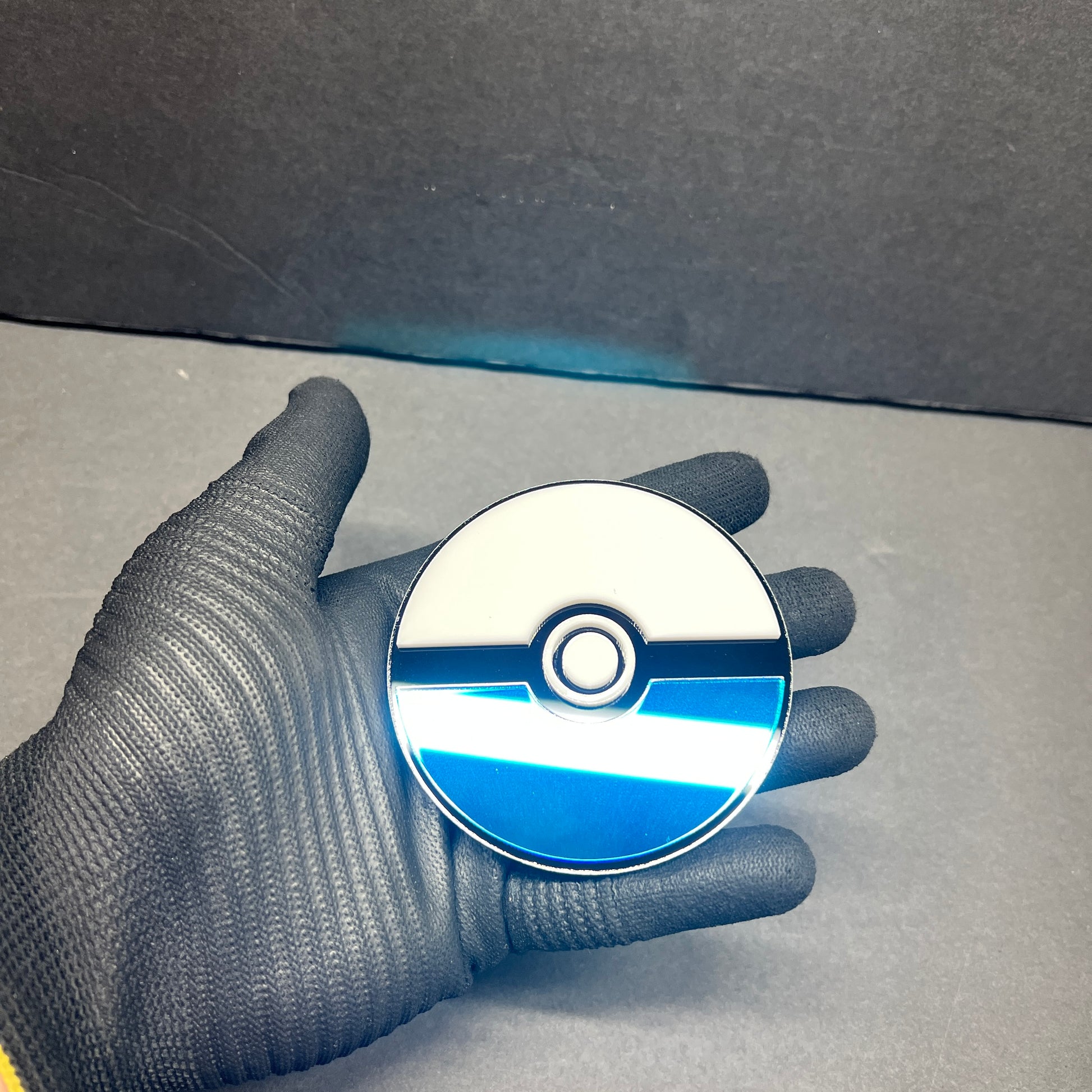 Pokemon inspired blue car badge exterior sticker held in hand