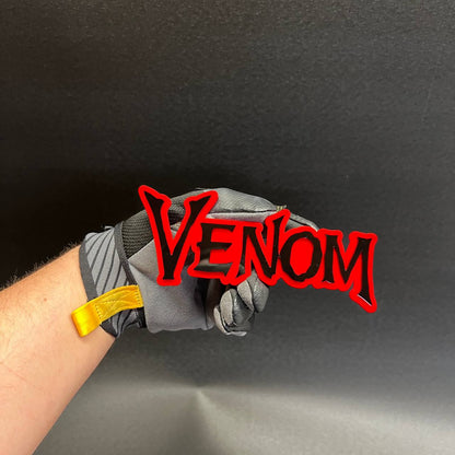 Closeup of VENOM custom text emblem with layered acrylic construction and glossy finish