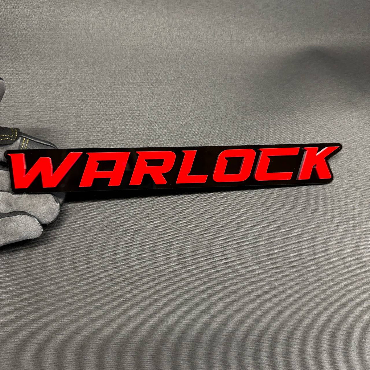 WARLOCK car badge with red lettering and glossy black background custom automotive emblem